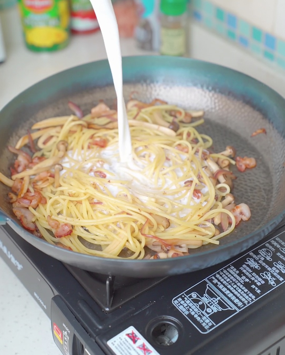 Leche vertiéndose en la sartén sobre la mezcla de pasta.