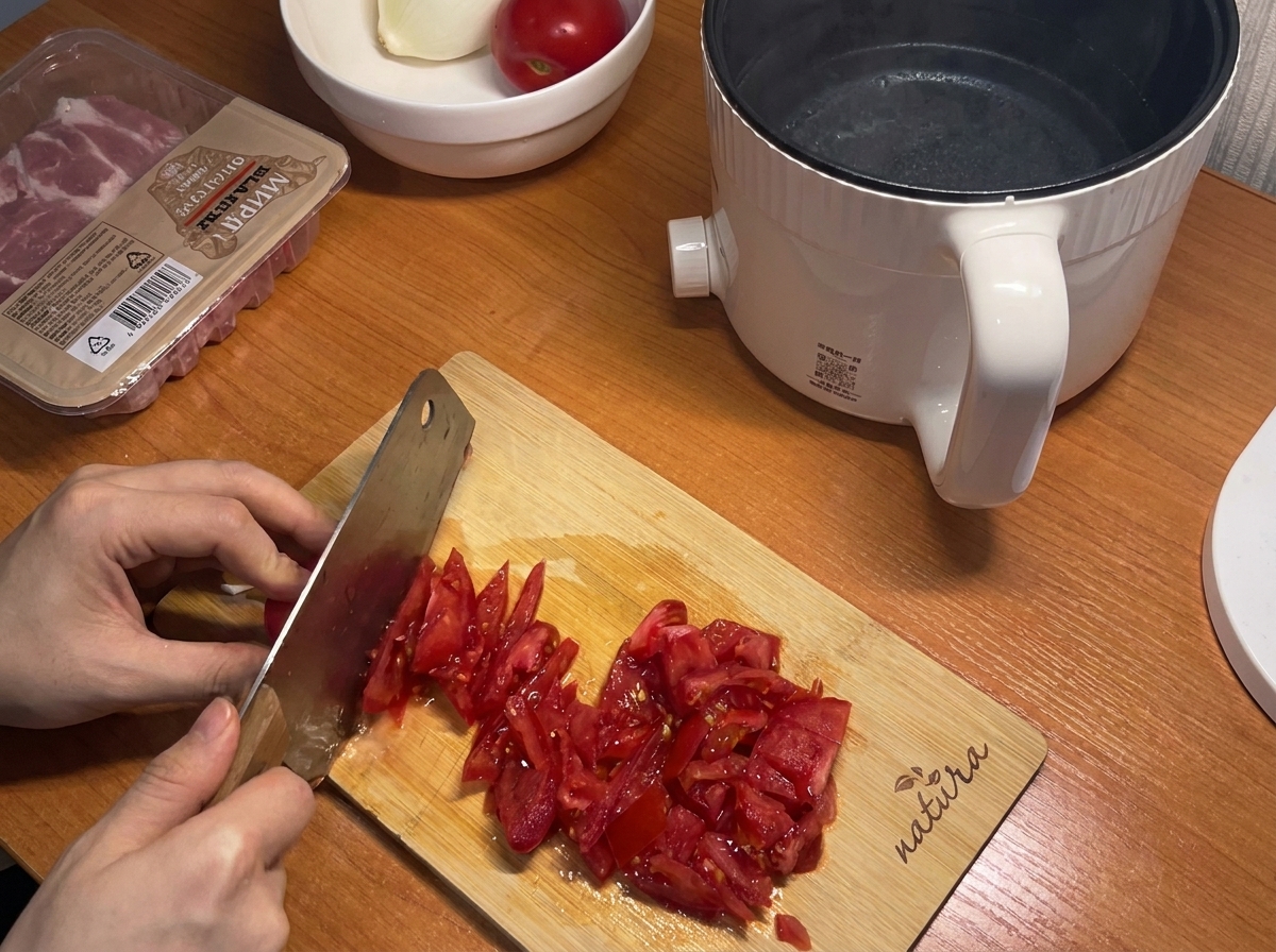 Tomates rojos frescos siendo cortados en trozos pequeños sobre una tabla de madera, listos para la salsa.
