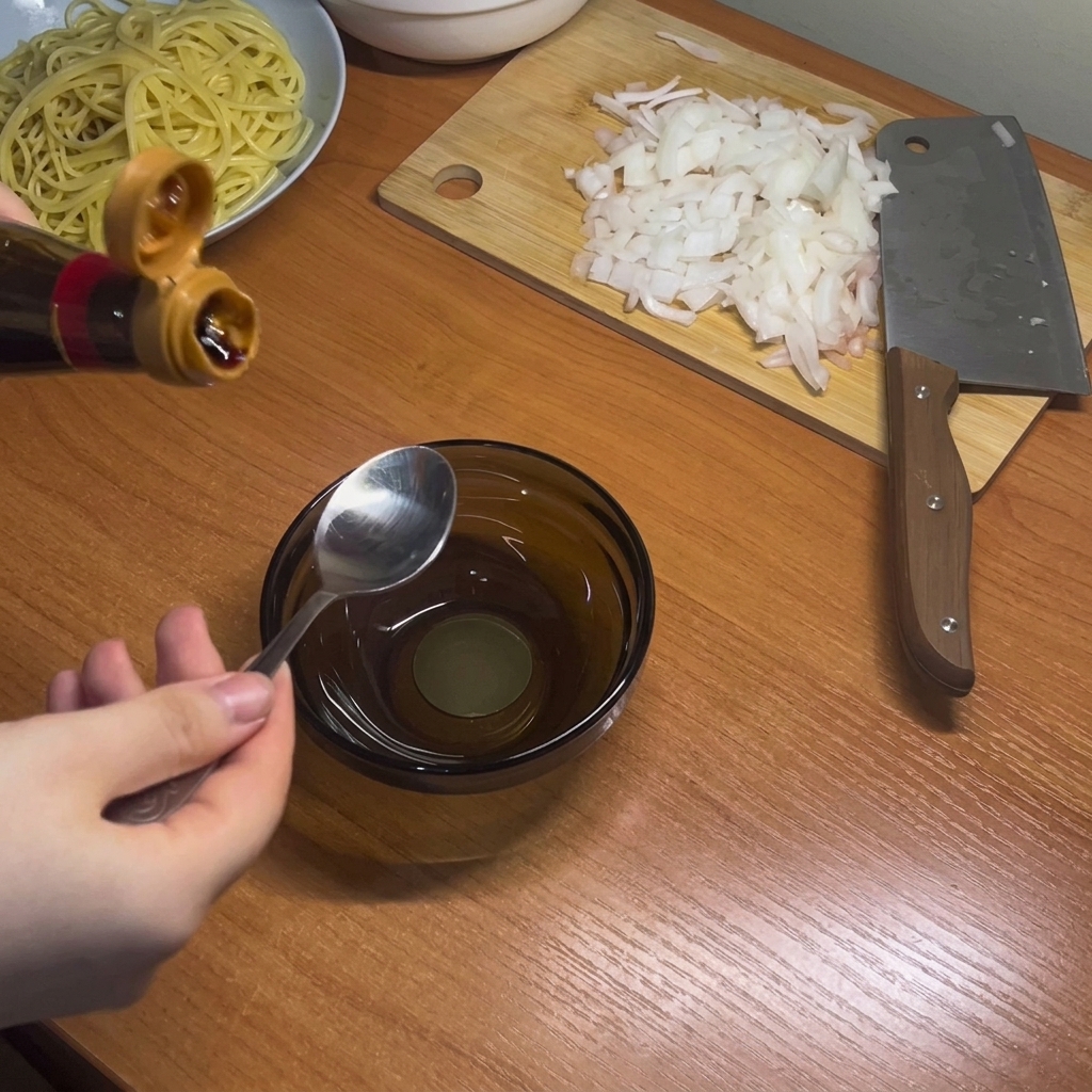 Salsas oscuras, incluyendo salsa de soja y de ostra, siendo mezcladas en un pequeño cuenco de cristal.