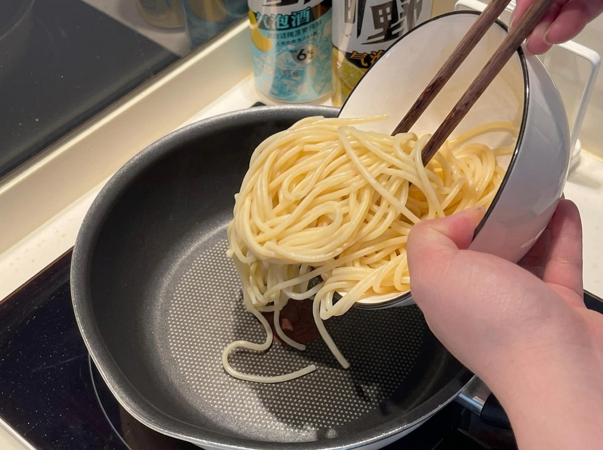 Fideos de espagueti añadidos a una olla con agua hirviendo.