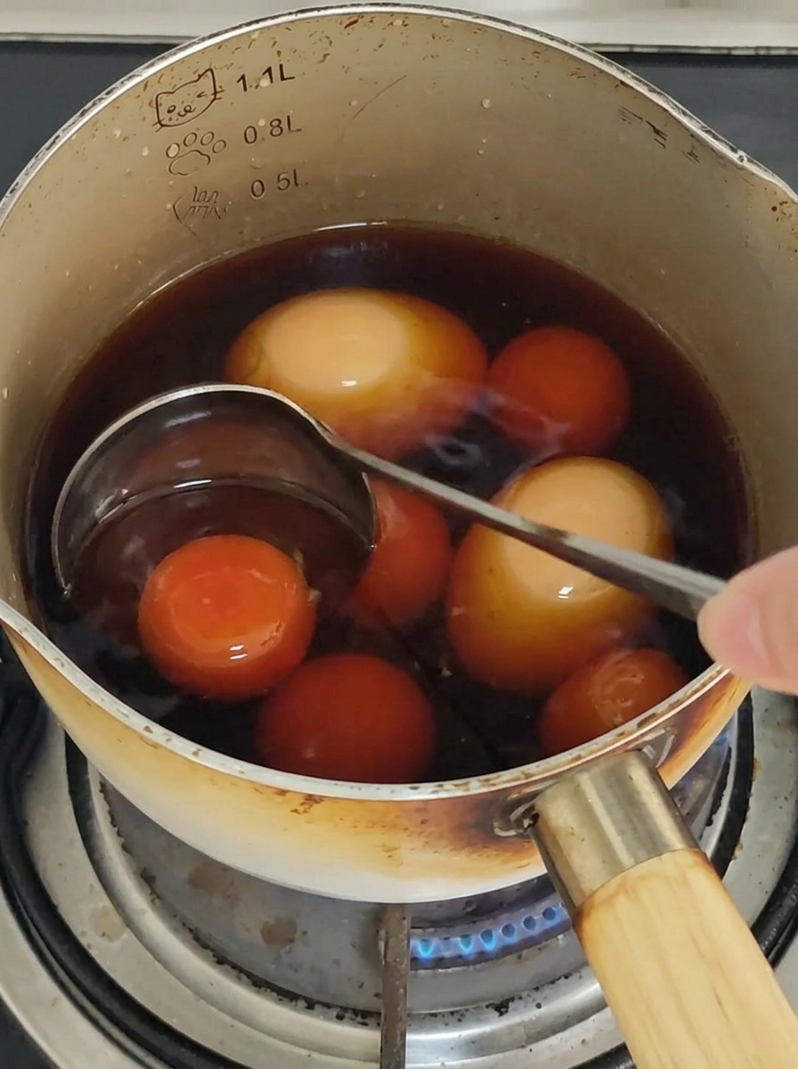 Espaguetis mezclándose con palillos en una sartén para cubrir con la salsa.