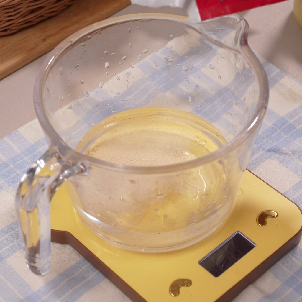 La levadura disolviéndose en el agua helada dentro de la taza medidora.