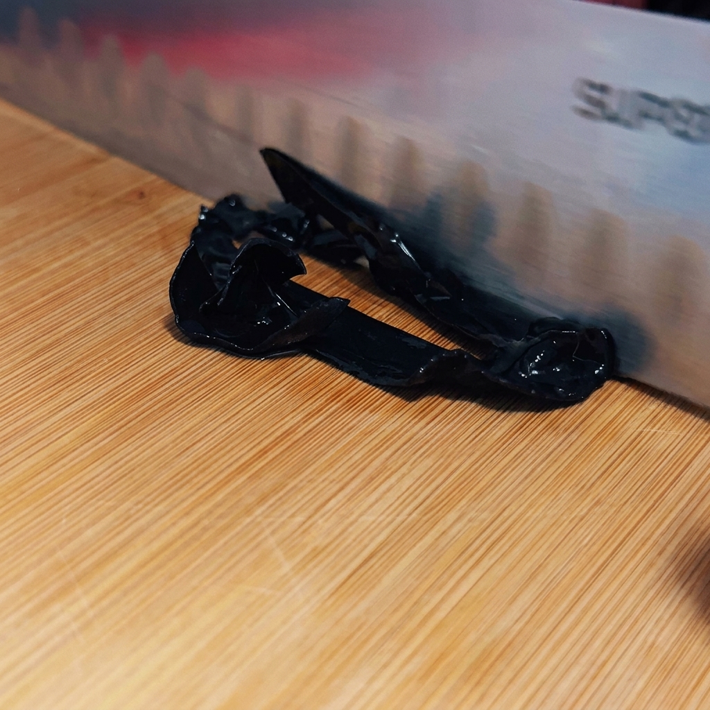 Un cuchillo afilado cortando los hongos en tiras oscuras y delgadas sobre una tabla.