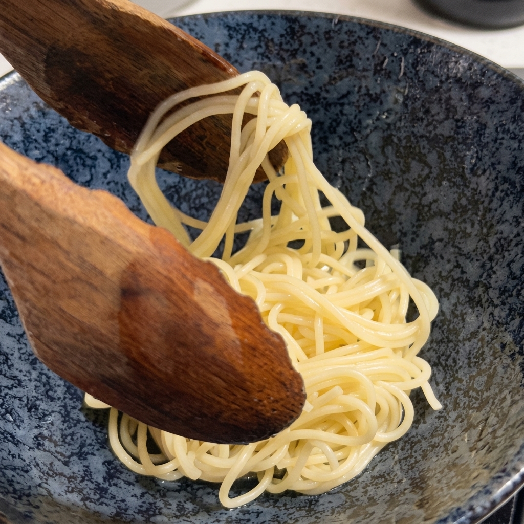 Fideos ramen cocidos siendo retirados de una olla con una cuchara de madera grande.