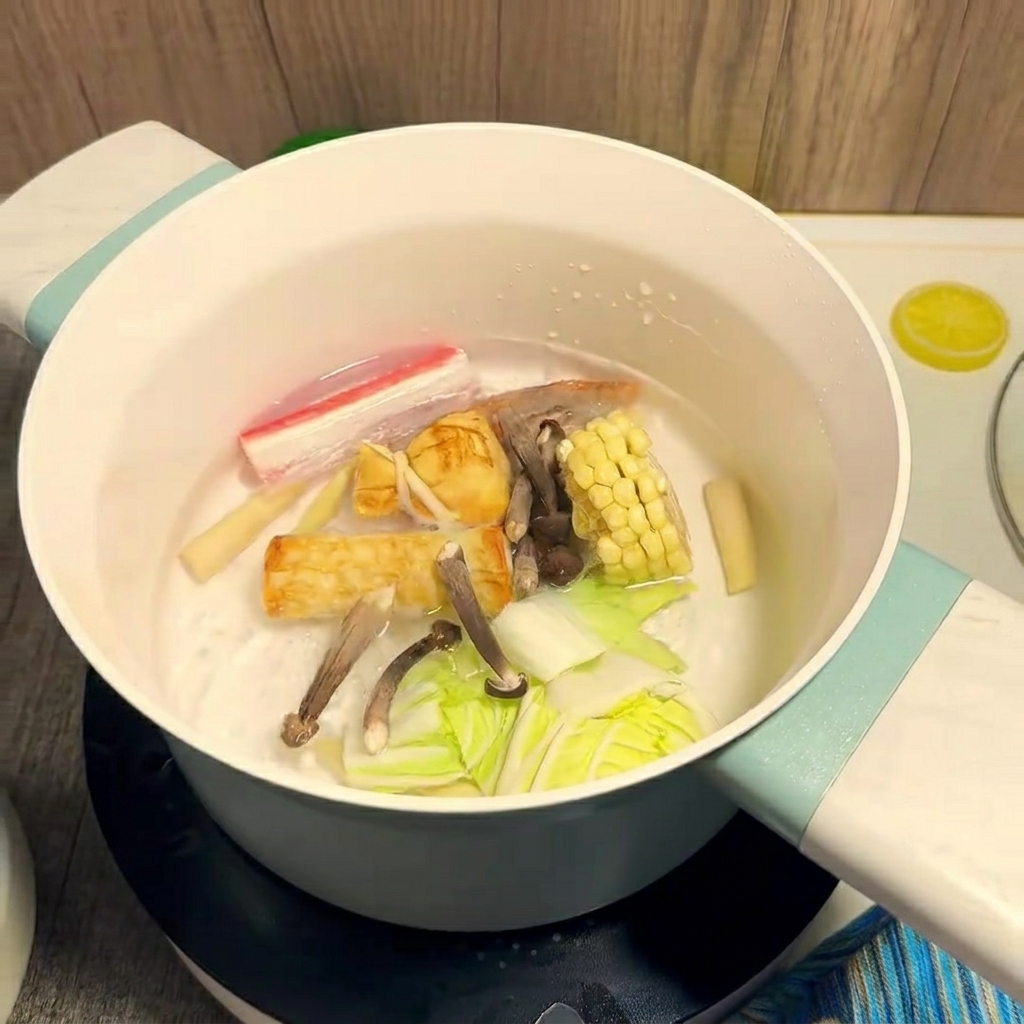Ingredientes coloridos como maíz y camarones cocinándose en una olla de agua hirviendo.