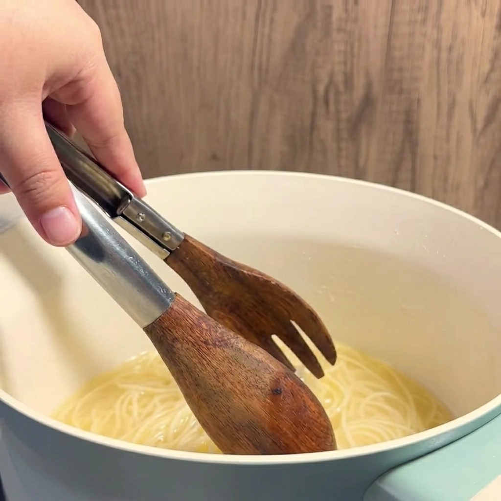 Caldo de maíz mantecoso caliente de color amarillo siendo servido con un cucharón en un vaso transparente.