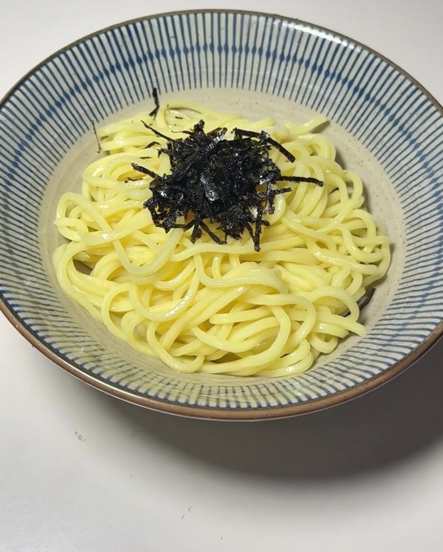 Un tazón de fideos decorado con algas, huevo y brotes de bambú.