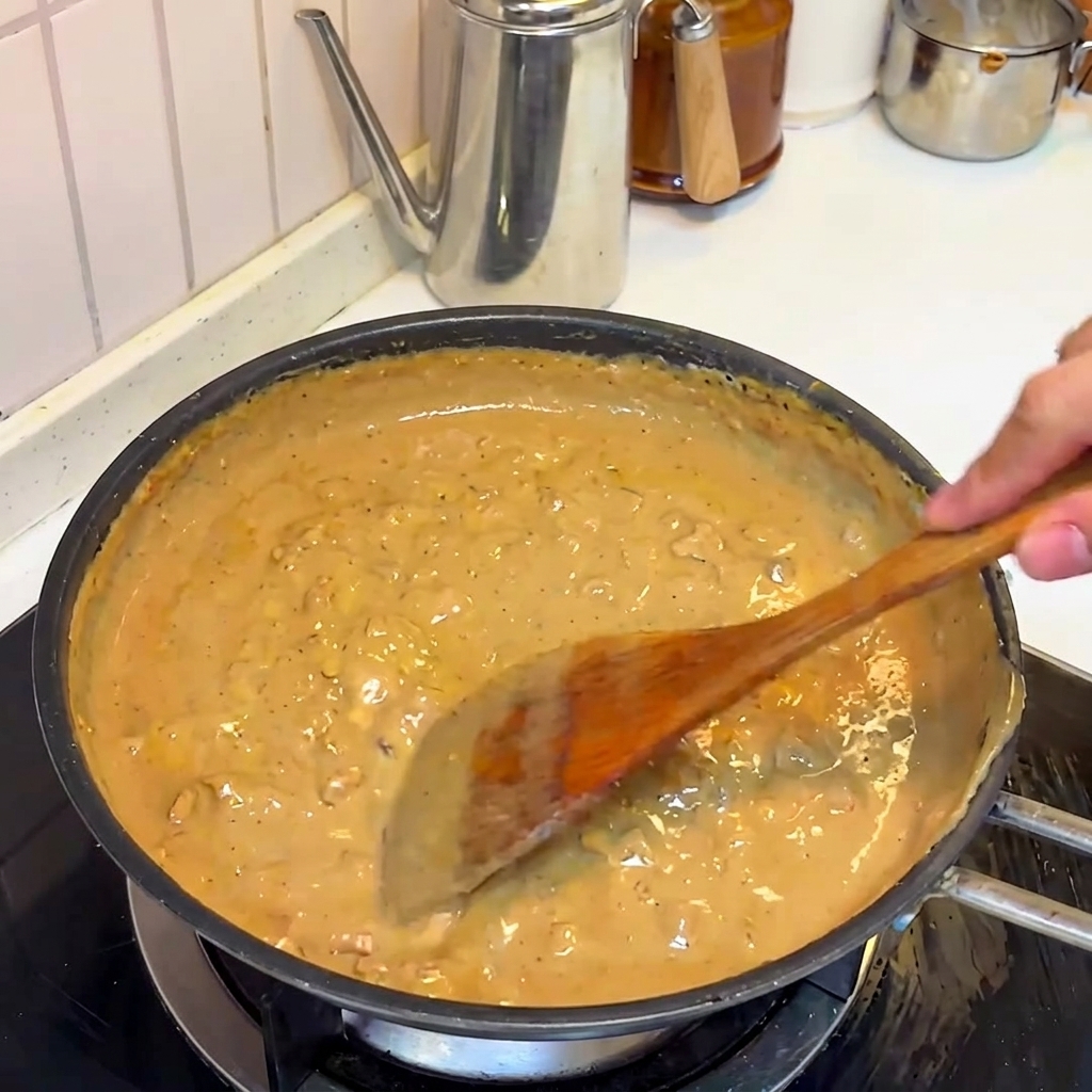 La rica salsa de miso y carne hirviendo y espesando en la sartén.