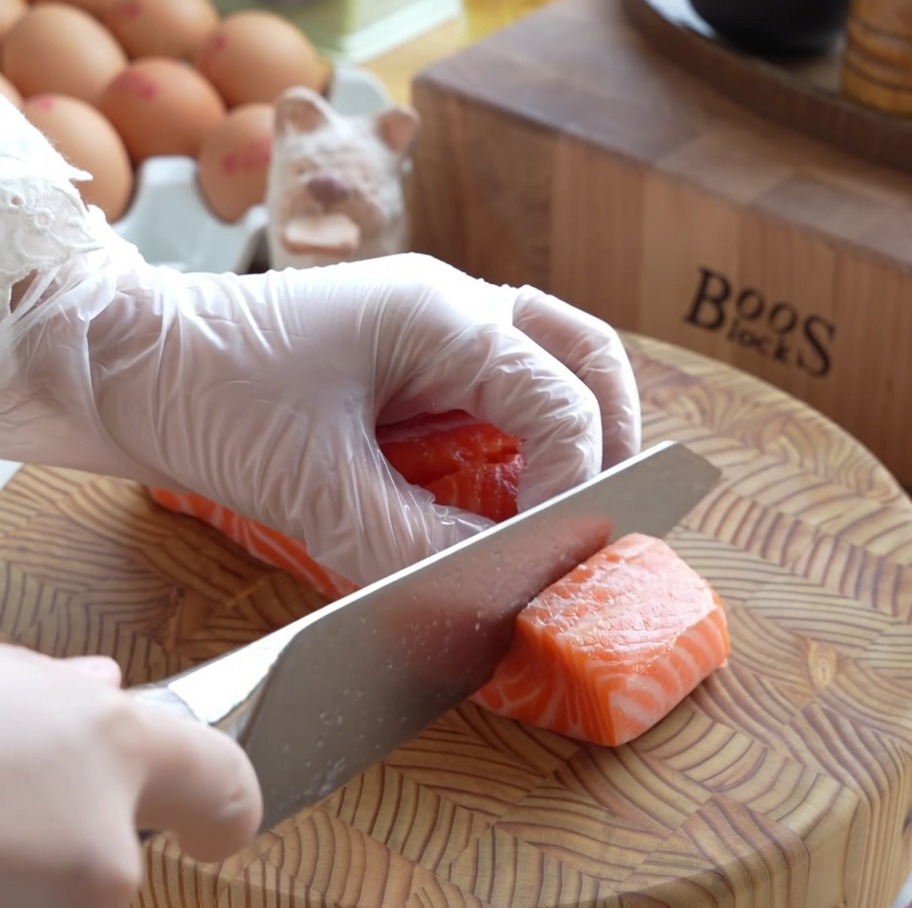 Dados gruesos de salmón fresco crudo preparados cuidadosamente en una tabla de cortar de madera.
