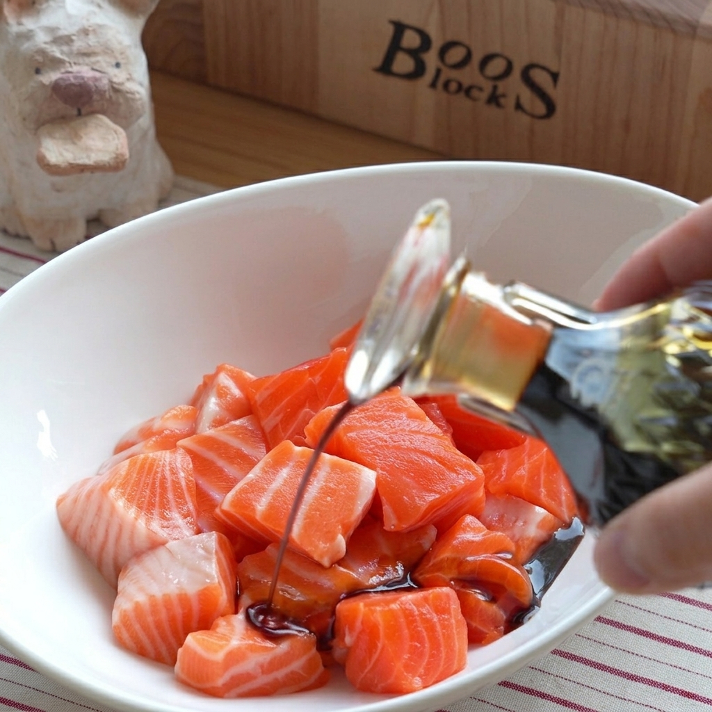 Un bol con dados de salmón crudo fresco mientras se vierten diversas salsas sobre ellos.