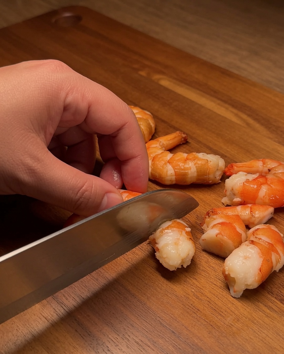 Filete de salmón crudo cortado en cubos uniformes y limpios sobre una tabla de madera.