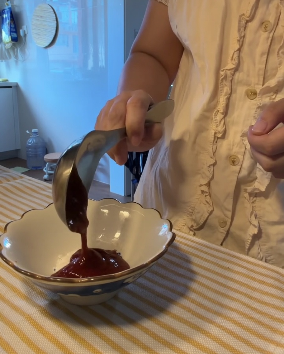 Una variedad de salsas y condimentos mezclándose en un pequeño tazón blanco.
