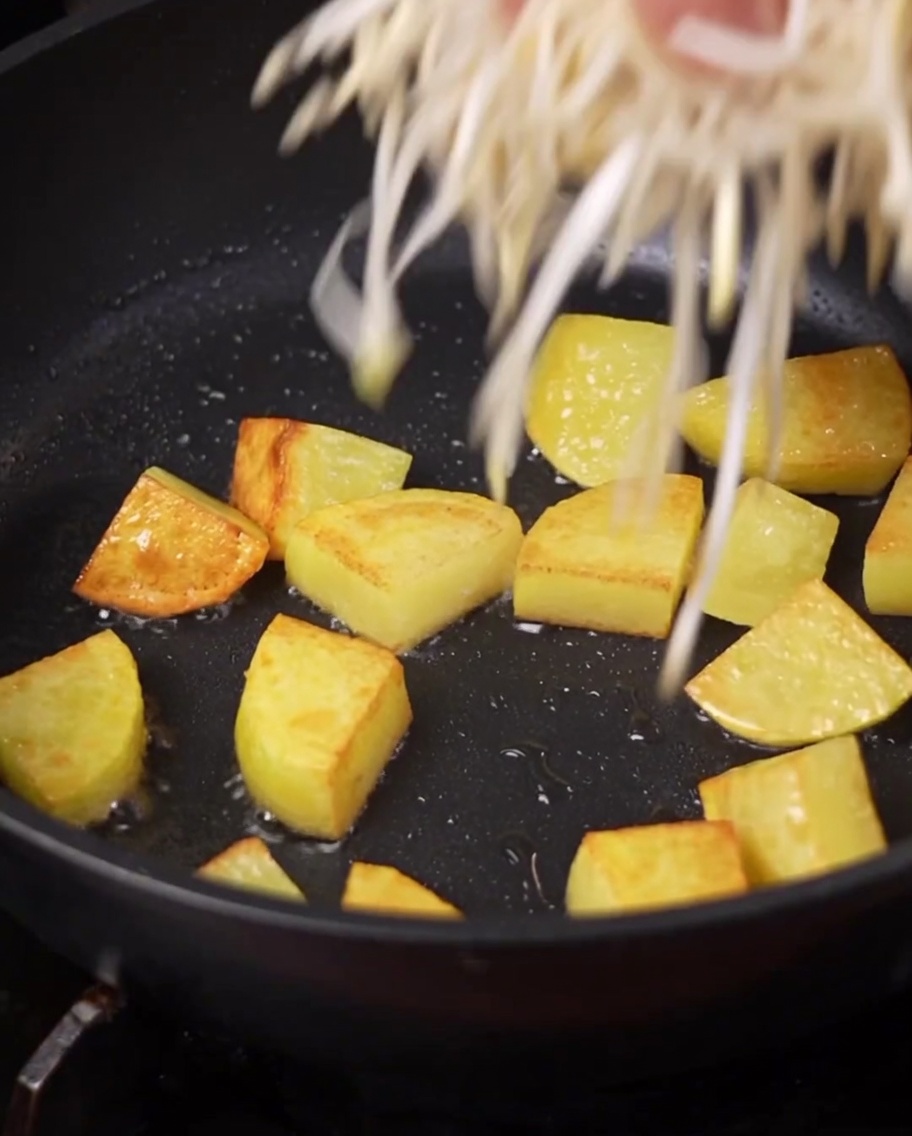 Brotes de soja frescos y un racimo de setas enoki siendo colocados en la olla.