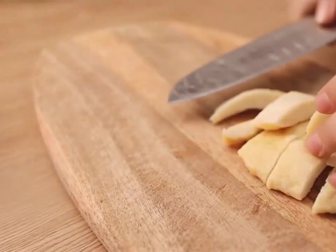 Primer plano de un cuchillo haciendo un corte en forma de I en una salchicha vegetariana.