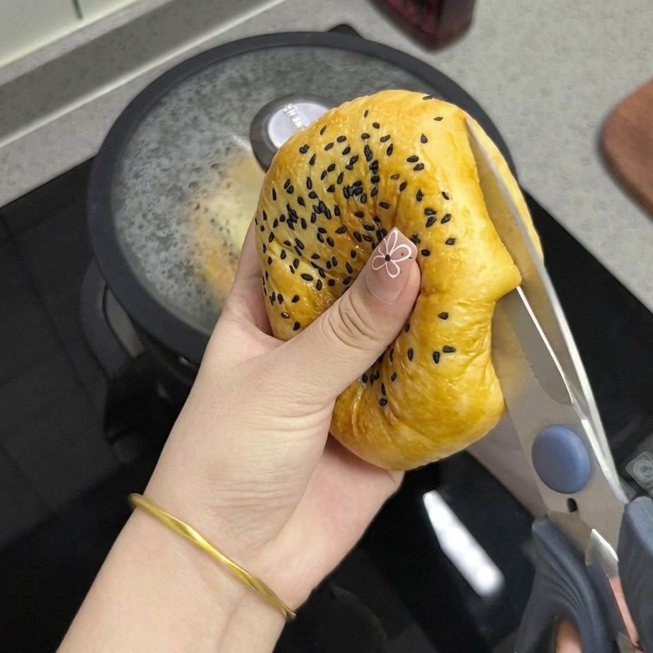 Primer plano de unas tijeras de cocina cortando el pan tostado por la mitad.