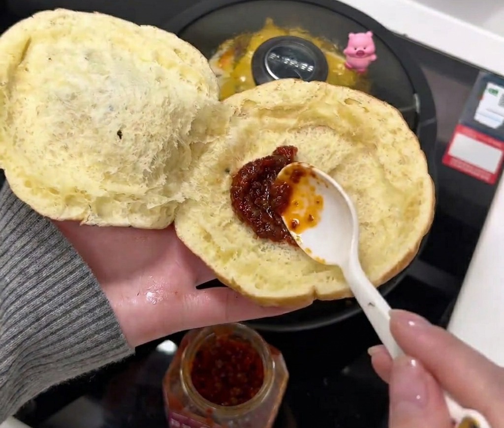 Extendiendo salsa de chile en el interior del pan.