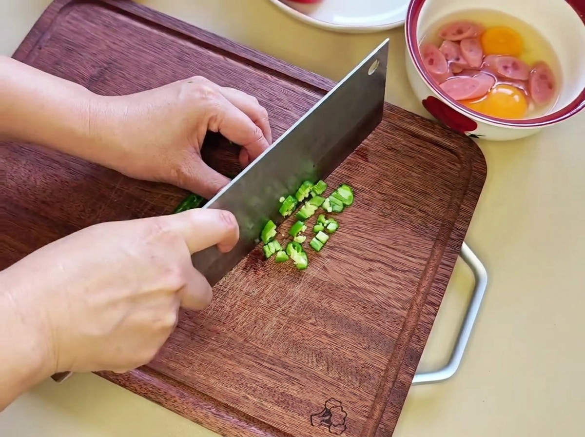 Trozos de chile verde picados finamente sobre una tabla de cortar de madera.