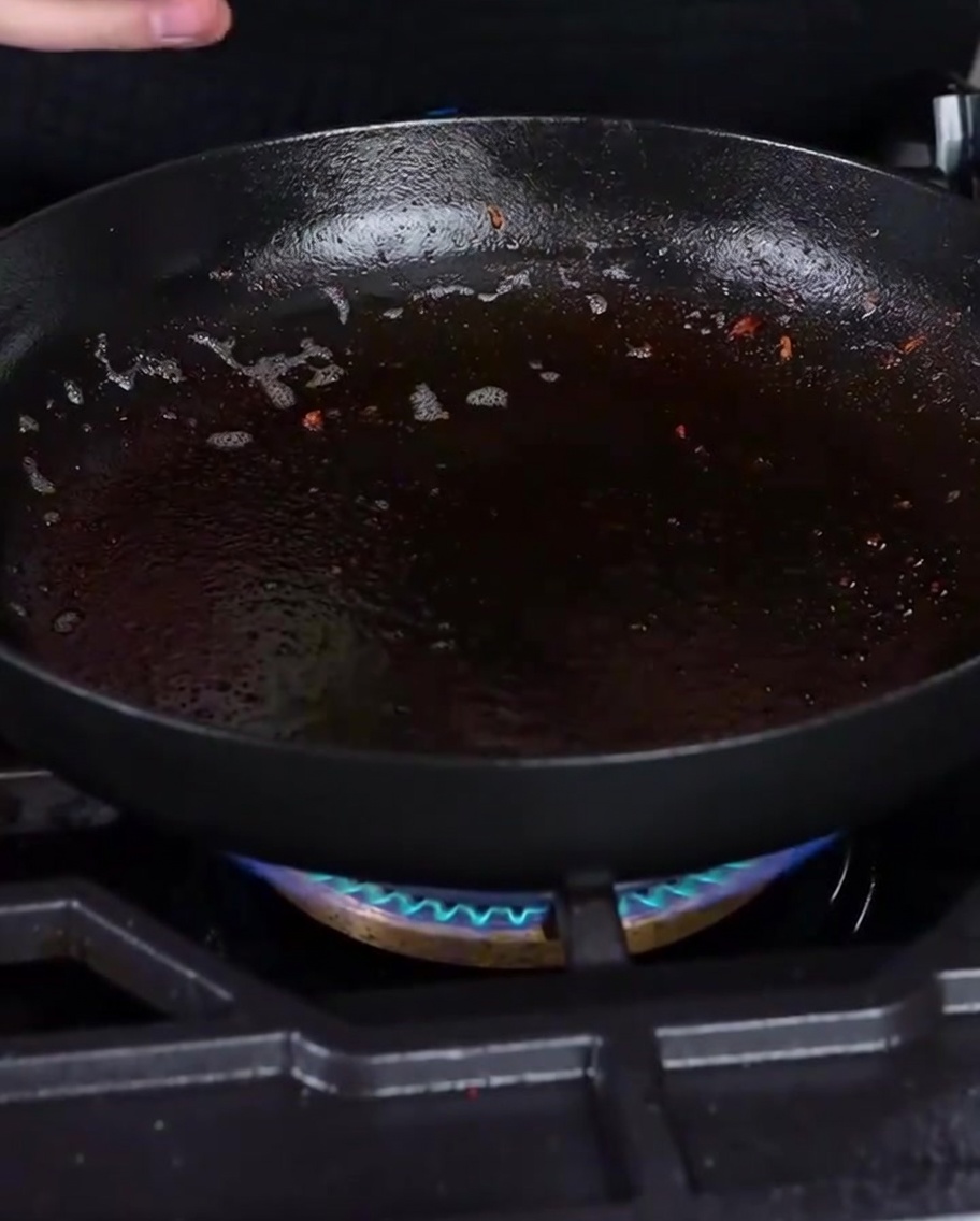 Cebollas picadas sofriéndose en la grasa residual del tocino.