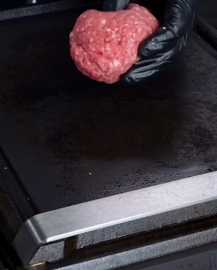 Bola de carne cruda sobre una plancha caliente.