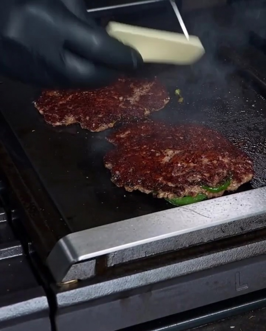Rebanada de queso Havarti derritiéndose sobre la hamburguesa.