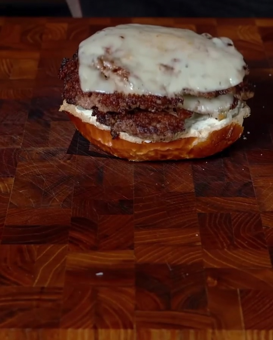 Apilando dos patties con queso sobre el pan.