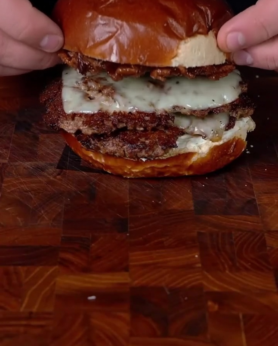 Colocando la tapa del pan sobre la hamburguesa ya montada.
