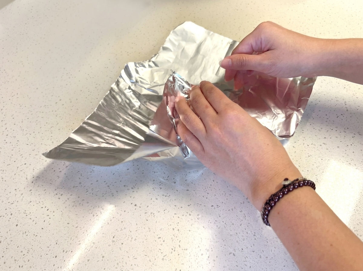 Panes de hamburguesa envueltos individualmente en cuadrados de papel de aluminio.