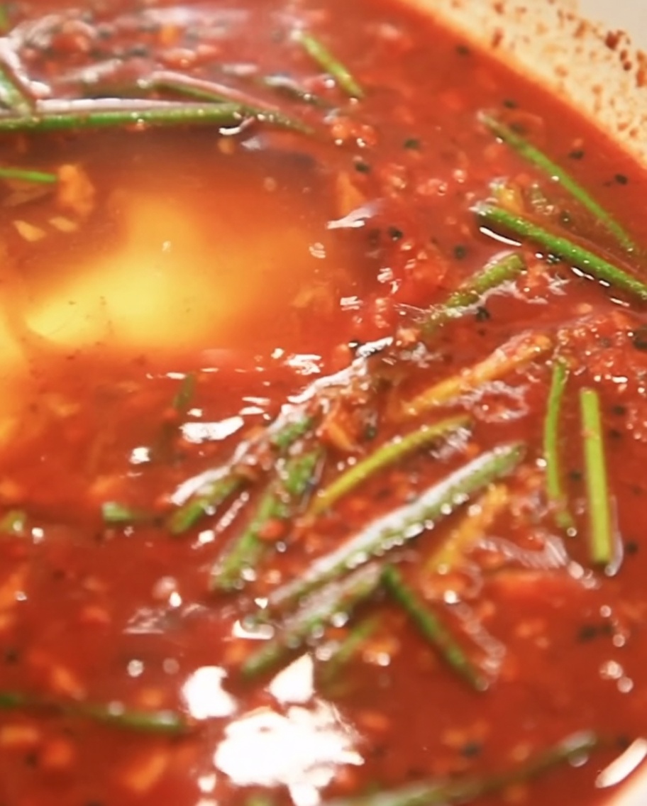 Polvo de almidón siendo espolvoreado en la base del adobo rojo.
