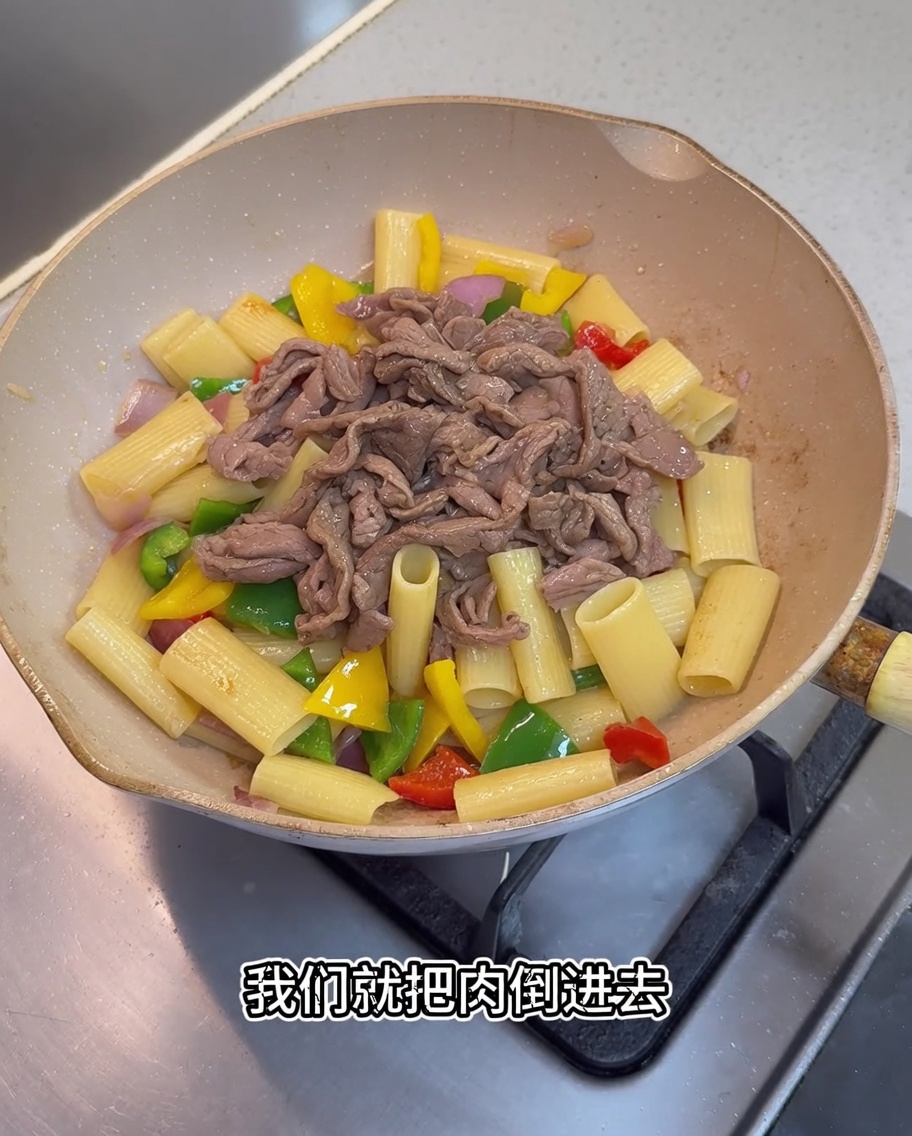 Trozos de cerdo cocidos y una salsa oscura siendo añadidos a la sartén.