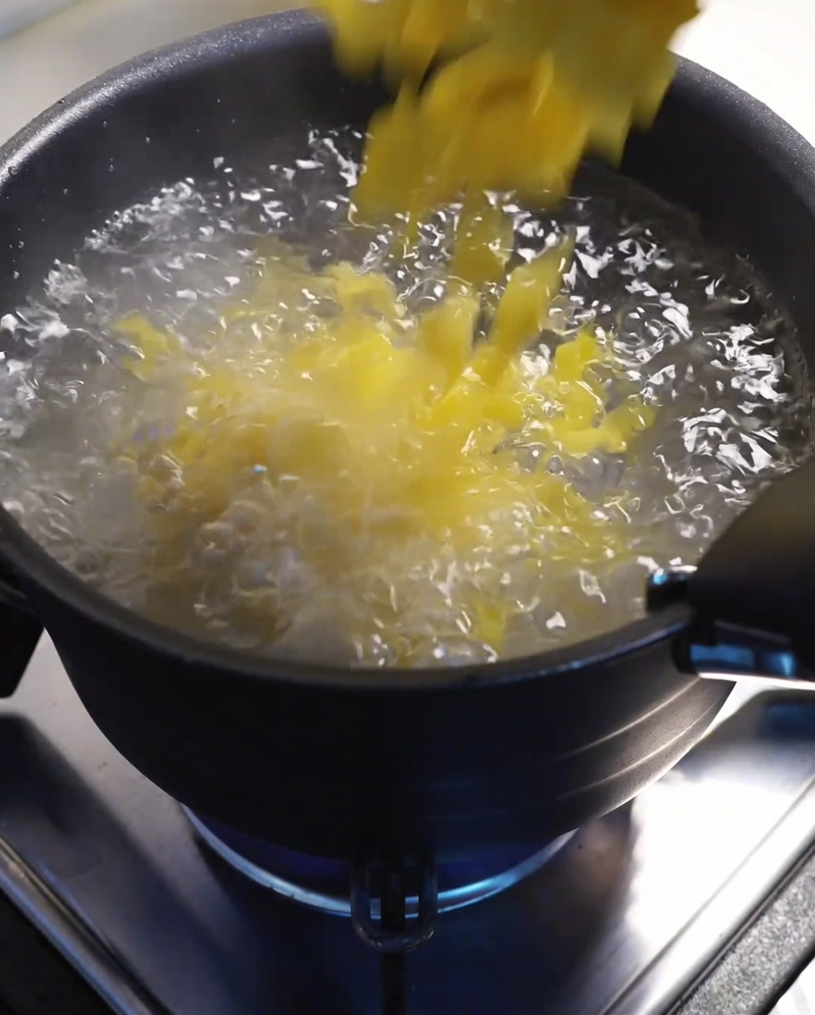 Macarrones hirviendo en una olla grande con agua en la estufa.