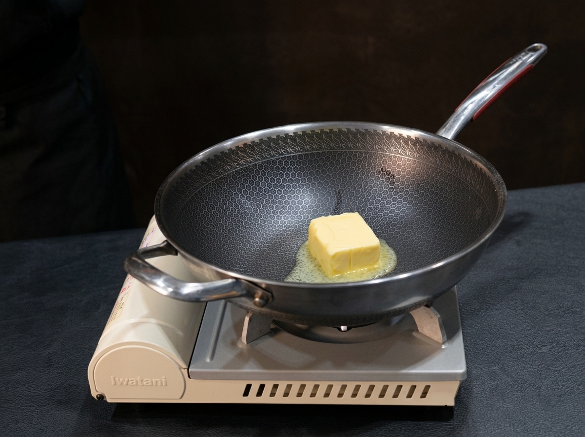 Mantequilla derritiéndose en una sartén mientras se incorpora harina con un batidor para formar un roux suave.