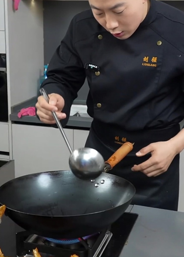 Un wok caliente con manteca de cerdo derritiéndose y aceite brillante, listo para los ingredientes.