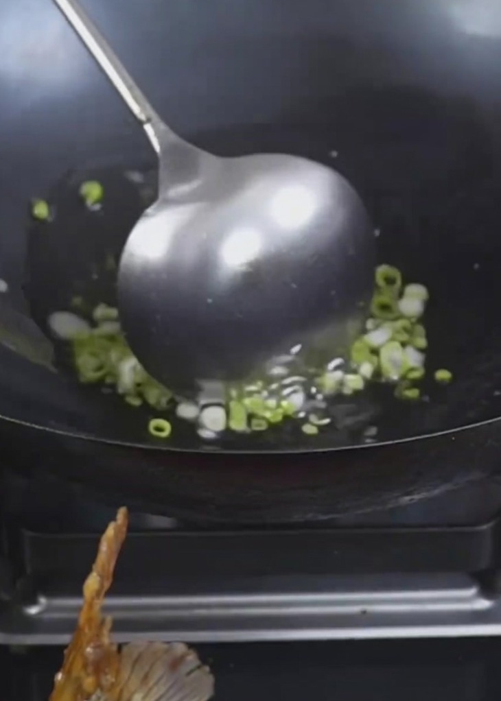 Cebolletas friéndose en aceite caliente hasta alcanzar un color dorado.