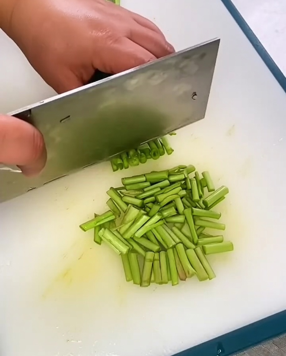 Cebollino chino fresco recién picado apilado en una tabla de cortar.