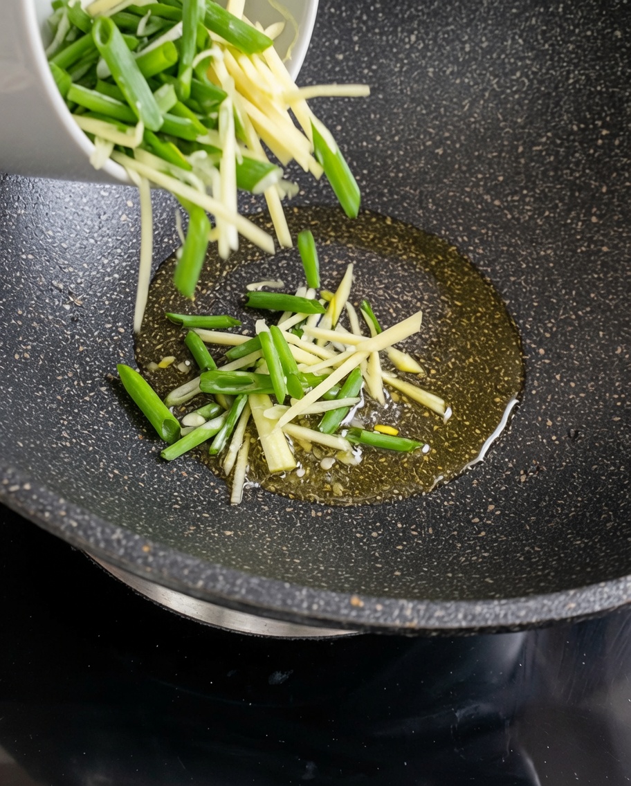 Tiras de papa cruda salteándose en un wok caliente con aceite.