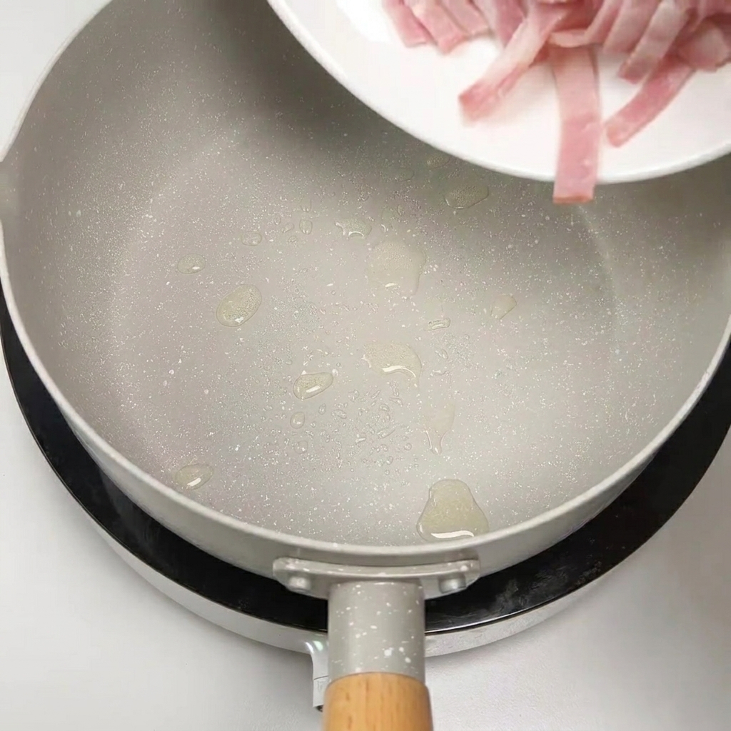 Tiras de bacon crudo siendo añadidas a una sartén para ser salteadas.