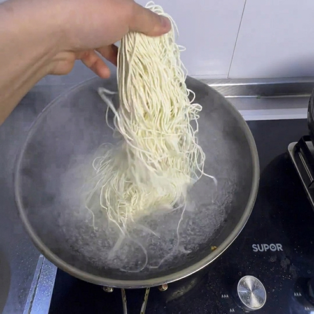Fideos y bok choy fresco hirviendo en una olla con agua.