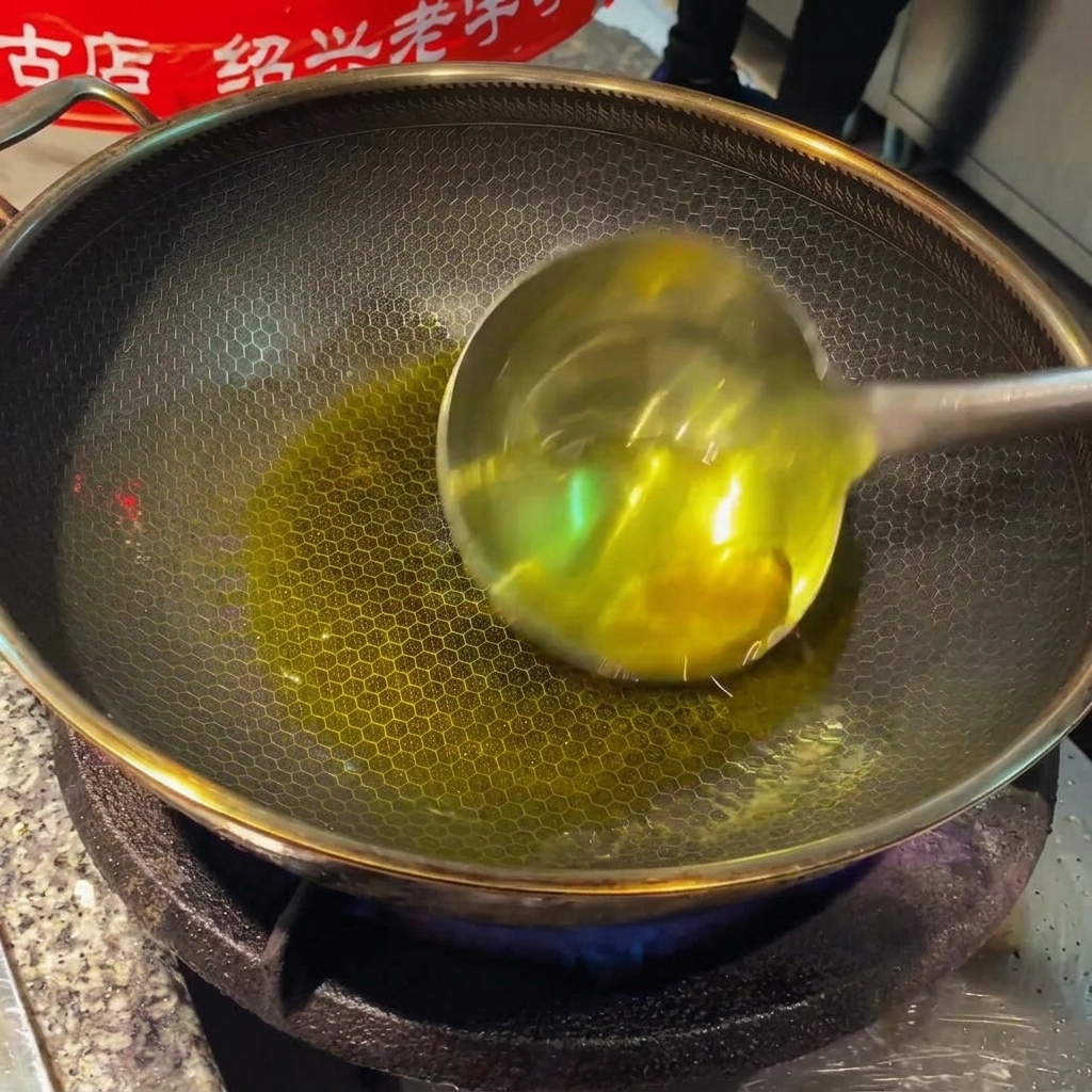 Rodajas de jengibre y dientes de ajo chisporroteando en aceite caliente dentro de un wok.
