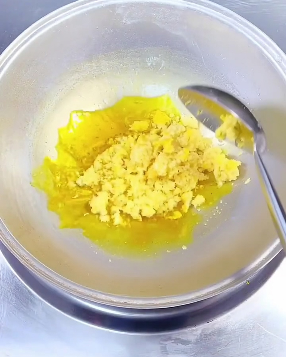 Ajo picado siendo sofrito en aceite de colza amarillo en un wok.