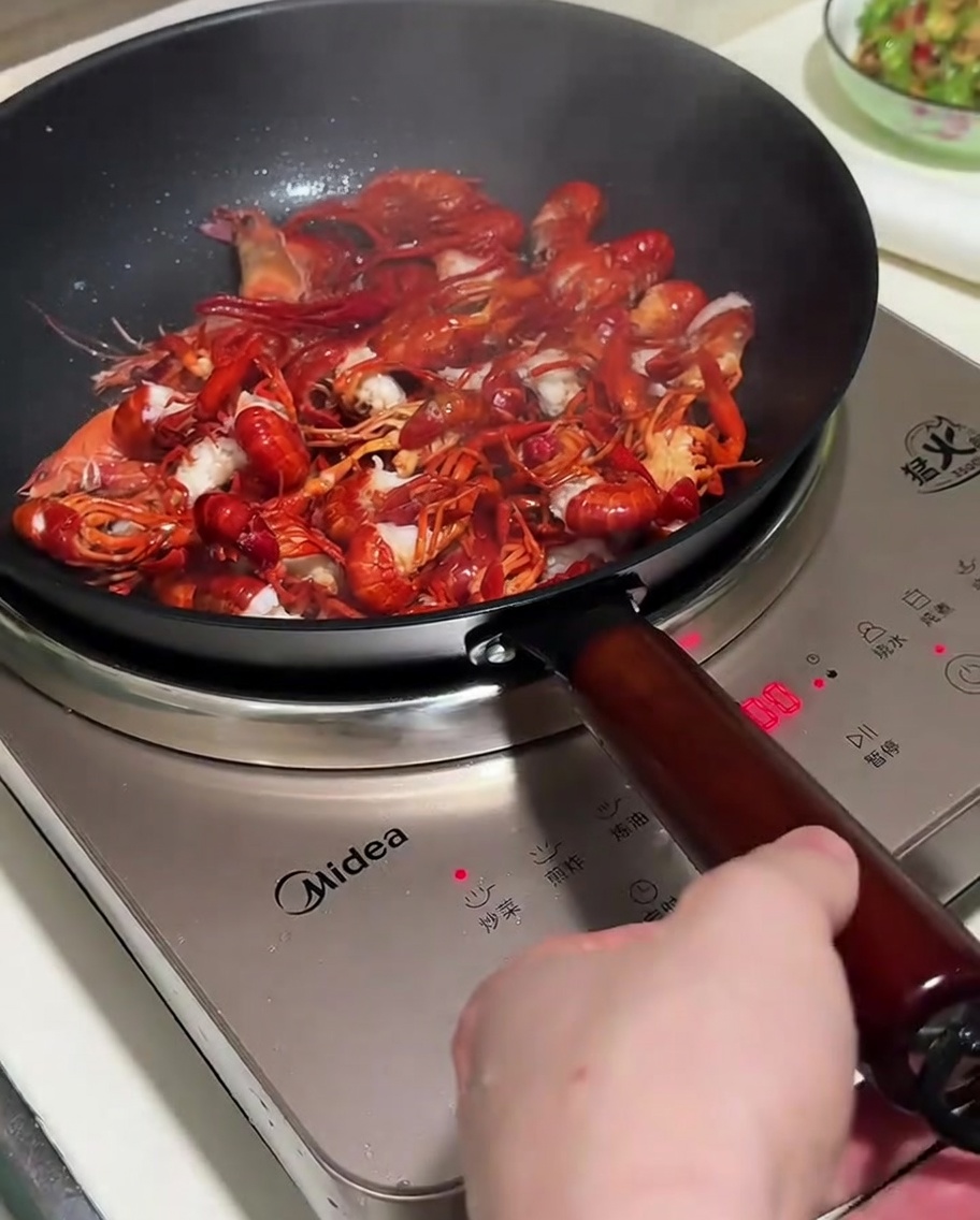 Salteando los cangrejos con los aromáticos en una sartén.