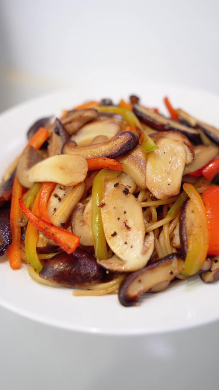 Espaguetis con setas a la pimienta negra servidos con setas shiitake y boletus salteadas, pimientos coloridos y pimienta recién molida.