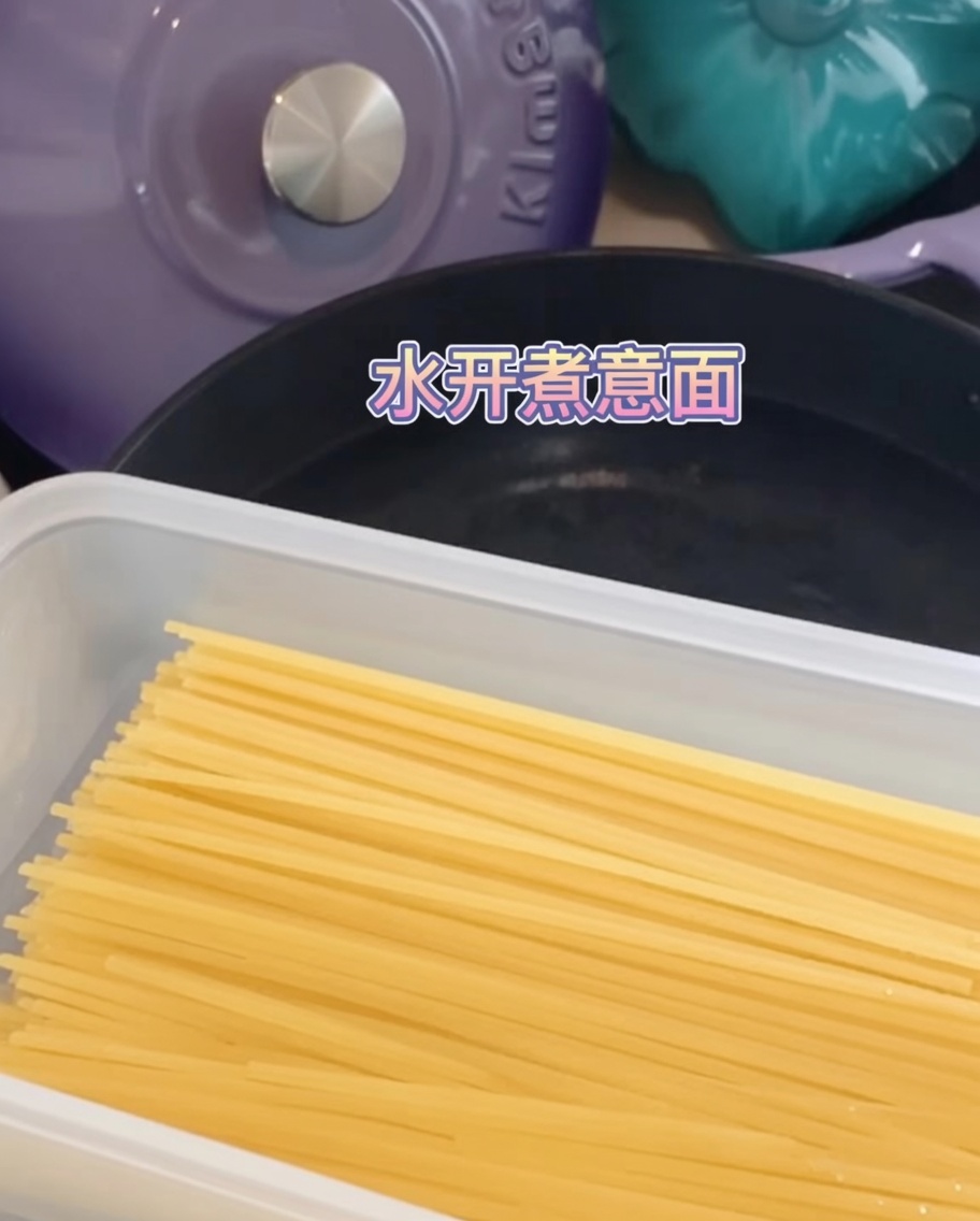 Fideos de espagueti sumergidos y cociéndose en una olla con agua hirviendo.