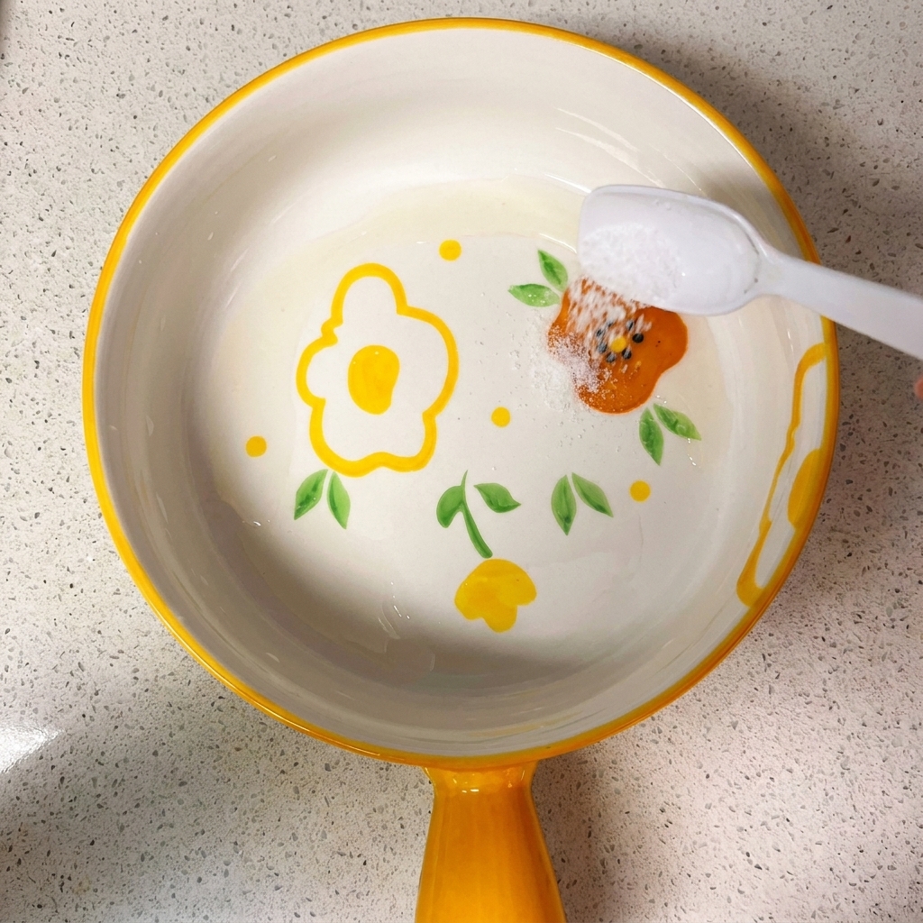 Un pequeño cuenco con una mezcla de salsas de soja, azúcar, sal, almidón de maíz y agua, siendo mezclado con una cuchara.