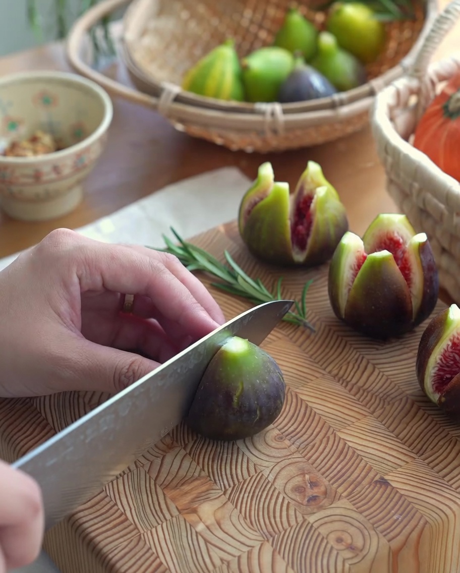 Higos frescos con un corte en cruz sobre una tabla de cortar de madera, listos para ser rellenos.