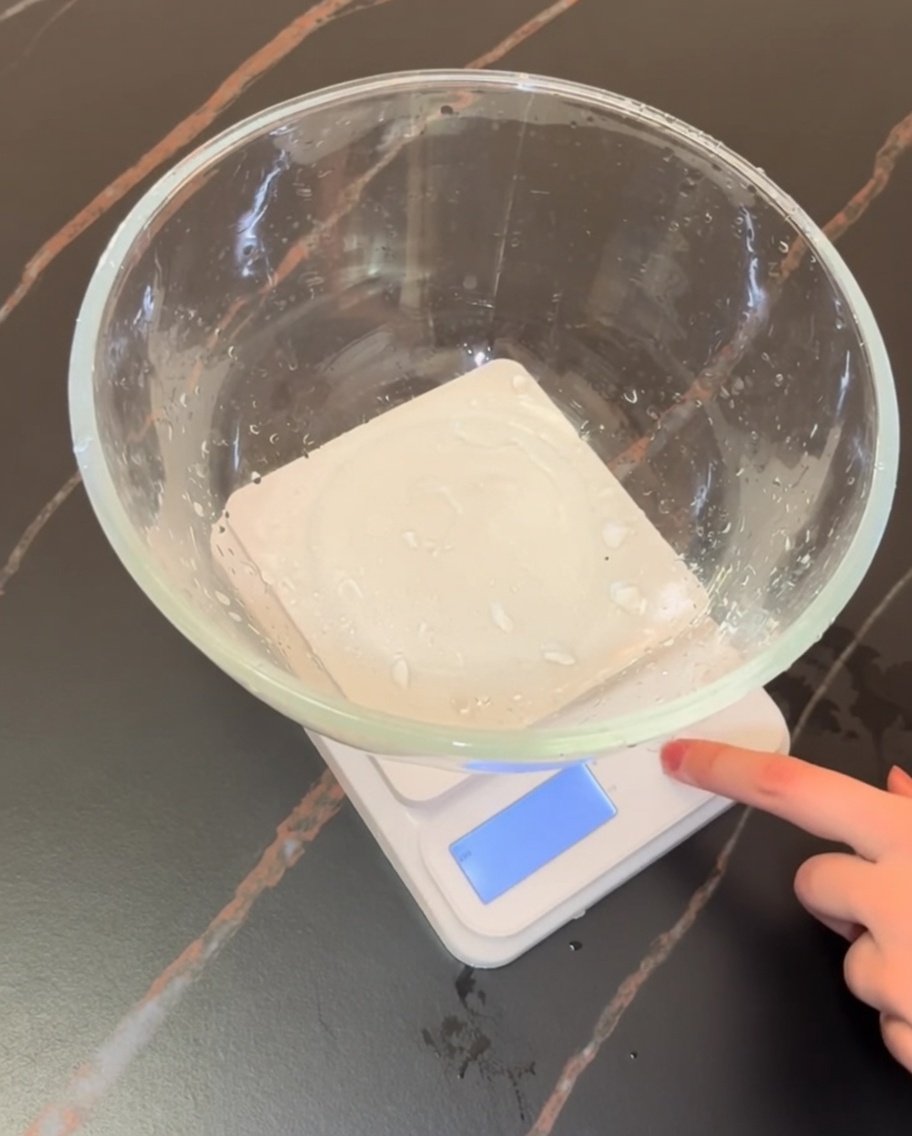 Báscula digital de cocina con un bol de cristal que contiene harina e ingredientes secos para pizza.