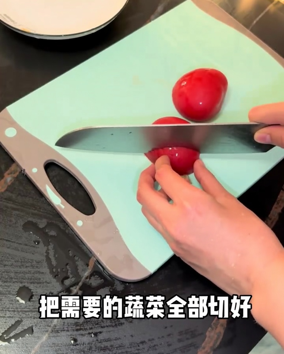 Tomates rojos frescos siendo cortados con un cuchillo de chef sobre una tabla de cortar verde.