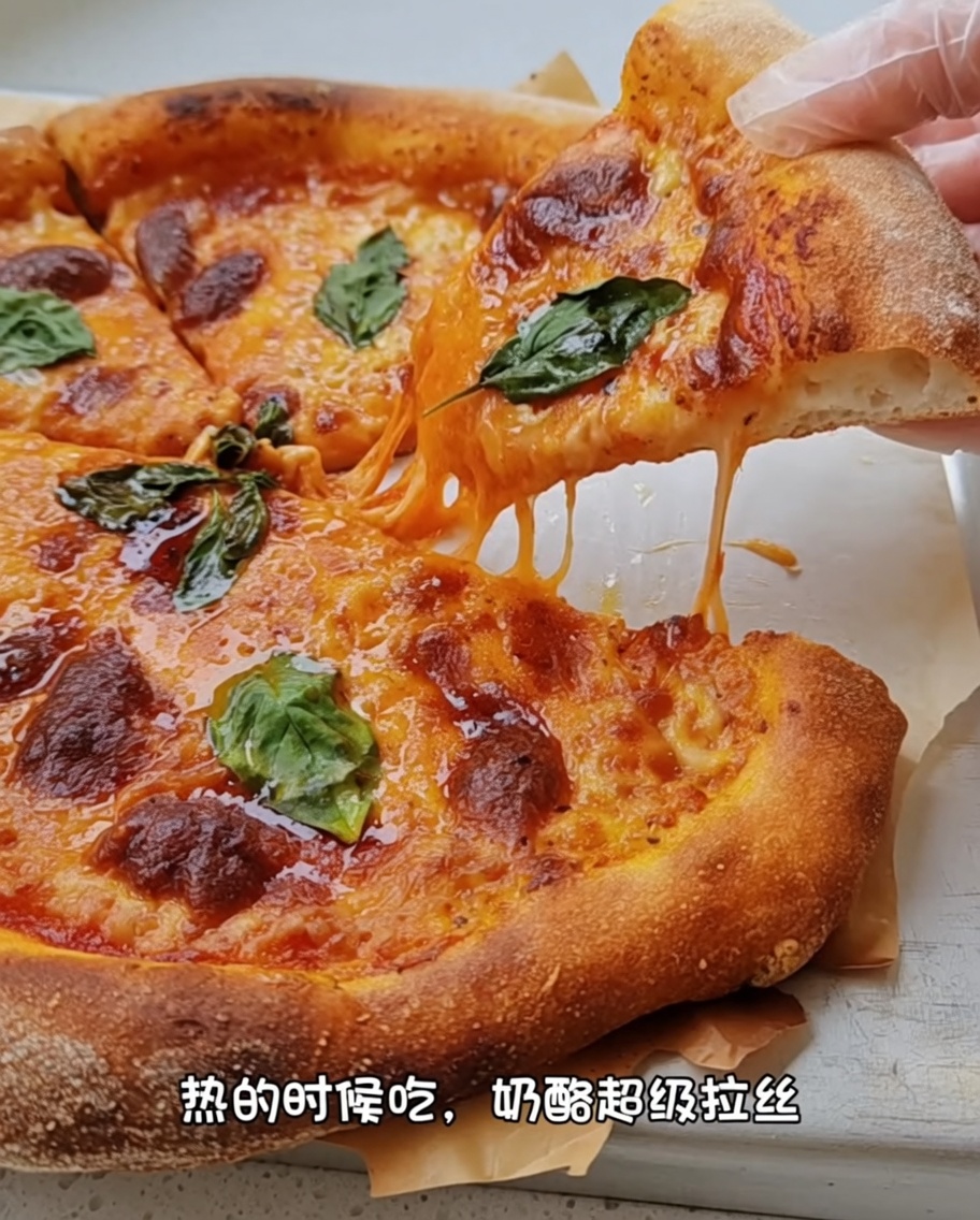 Manos usando los nudillos para estirar una base de pizza redonda sobre una superficie enharinada.