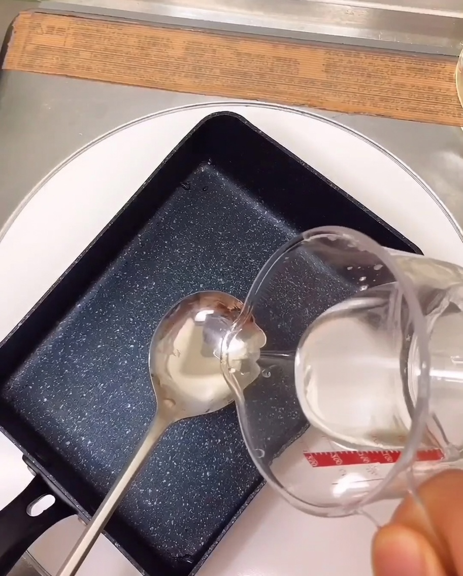 Ingredientes del marinado hirviendo en una sartén rectangular sobre la estufa.