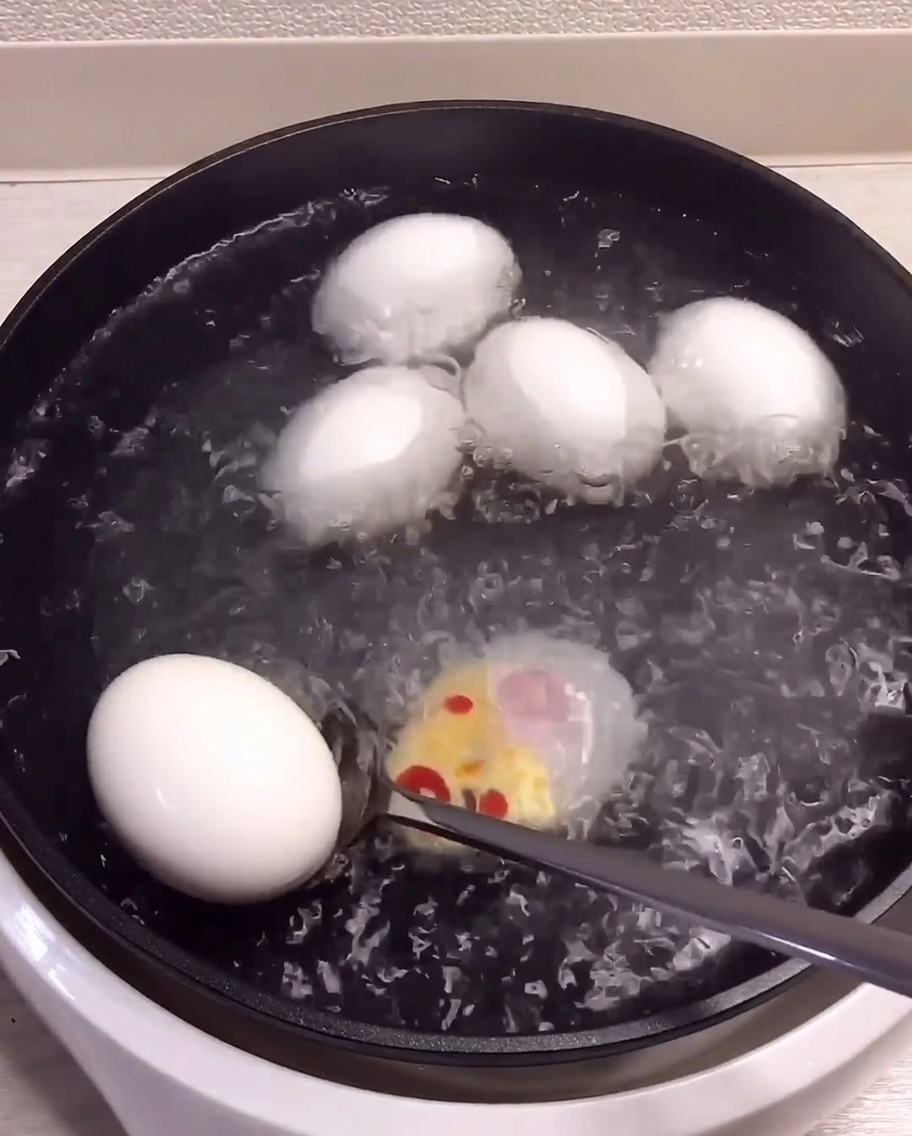 Huevos cocidos pasando de la olla a un bol con agua helada.