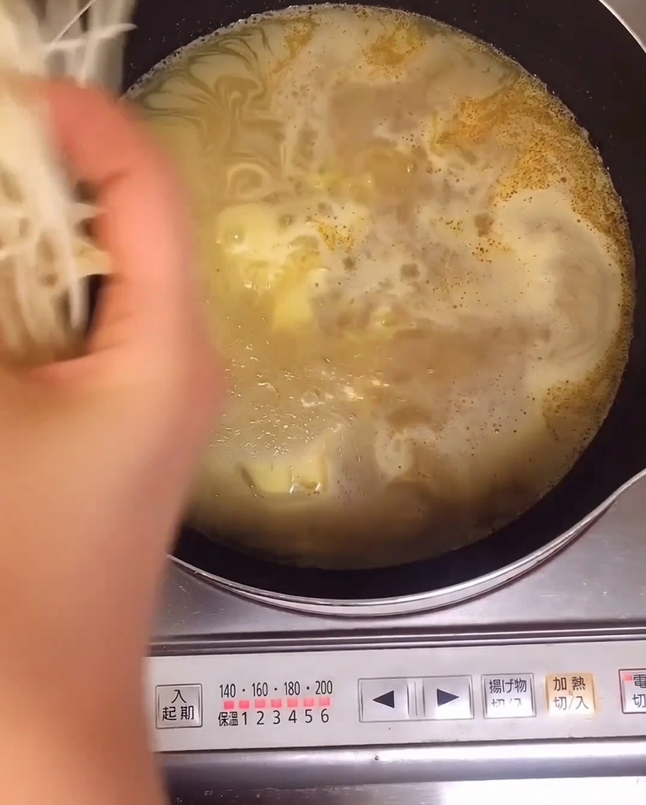 Brotes de soja frescos siendo añadidos a la olla con los fideos.
